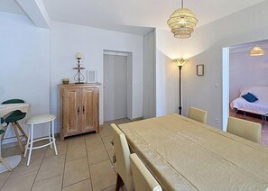 Ein Essbereich mit Tisch, Stühlen, einem Schrank und einer Lampe.