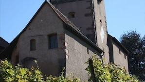 Ein Gebäude mit einem markanten Turm und einem kleineren Anbau.
