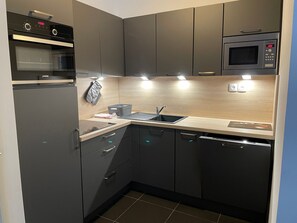 Uma cozinha moderna com eletrodomésticos embutidos, uma pia e armários.