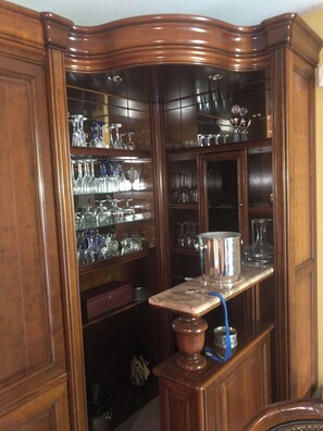 Ein Eckschrank mit Gläsern und einem Metalltopf auf einer Marmorarbeitsplatte.