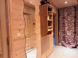 Une pièce en bois avec un mur incurvé, une étagère et un rideau à motifs.