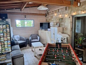 A cozy room with a foosball table, a television, a sofa, and a small table. - Mobile home terrace - 4 guests (Rocamadour)
