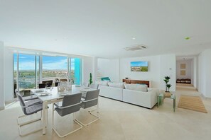 Una sala de estar moderna con comedor, ventanas amplias y vista a la ciudad.