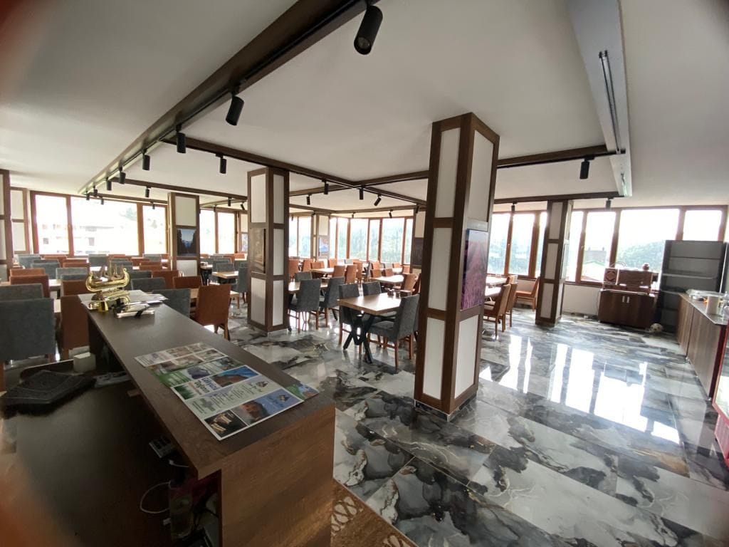 A spacious office with multiple workstations, a reception desk, and large windows providing natural light.