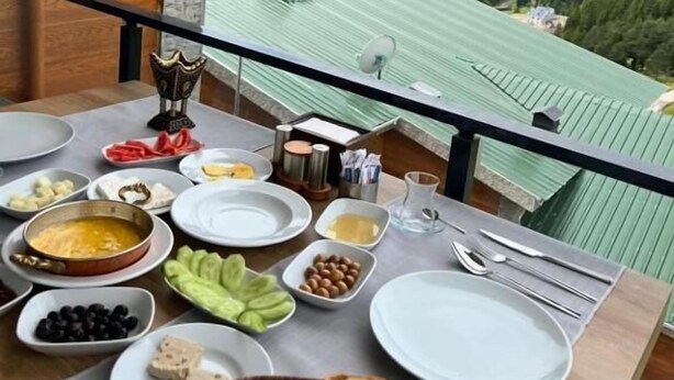 Una mesa dispuesta con diversos alimentos y una vista de un paisaje montañoso.