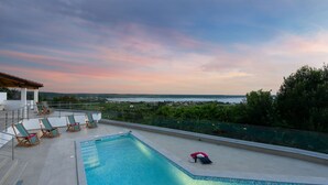 Ein Pool auf dem Dach mit Liegestühlen und Blick auf die Landschaft.