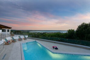 Ein Pool auf dem Dach mit Liegestühlen und Blick auf die Landschaft.