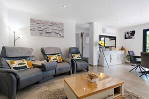 Ein modernes Wohnzimmer mit einer Sofagarnitur, einem Couchtisch und einem Gemälde an der Wand.