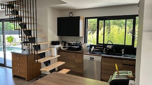 Eine moderne Küche mit eingebautem Geschirrspüler, einer Kaffeemaschine und einem Toaster.