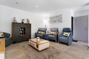 Ein modernes Wohnzimmer mit einer Sofagarnitur, einem Schrank und einem Couchtisch.