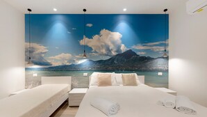 Un dormitorio con una cama, dos mesitas de noche, una lámpara de pared y un mural panorámico grande.