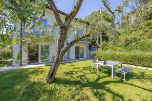 A house with a patio, a table, and chairs. - Apartment 'Appartamento Alessandra' with Lake View, Wi-Fi and Air Conditioning (Garda)