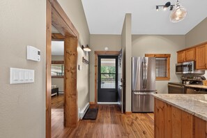 A kitchen with wooden cabinets, stainless steel appliances, and a marble countertop. - Spacious, renovated 2 bedroom, vaulted ceilings, private deck (Winter Park)