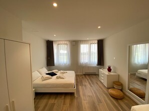 A bedroom with a bed, a dresser, a mirror, and a window with curtains. - Apartment 'Matilde' with Lake View, Wi-Fi and Air Conditioning (Garda)
