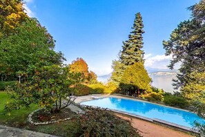 A swimming pool surrounded by trees and a view of mountains.