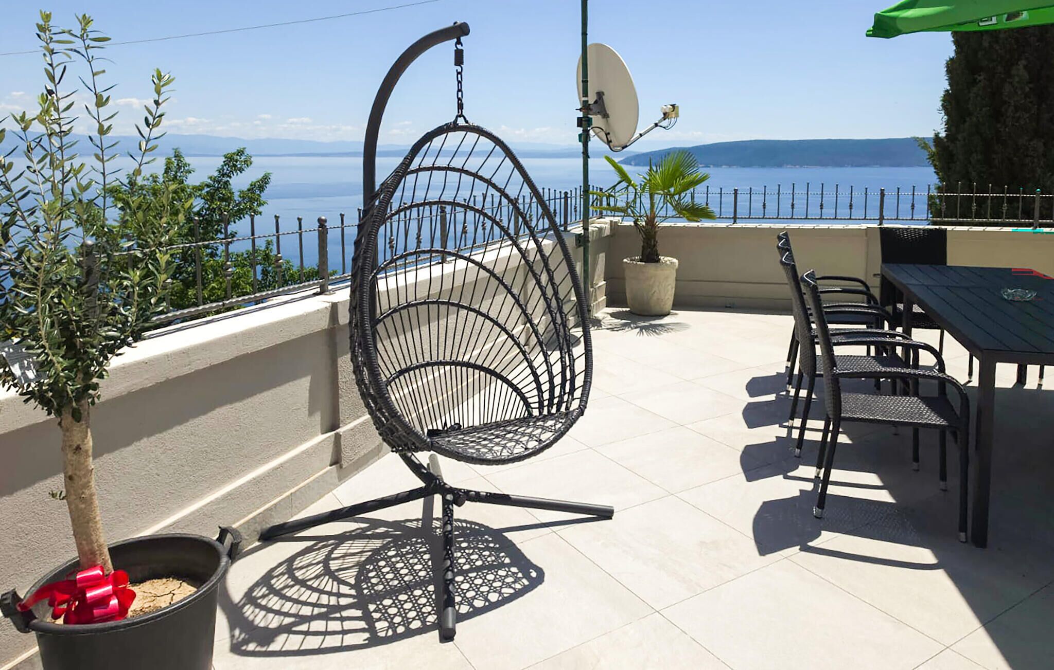 Un patio con una silla, una mesa y plantas en macetas.