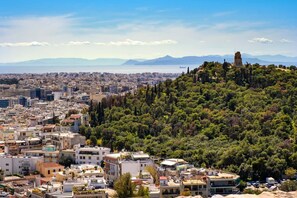 A cityscape with a hilltop monument, dense urban buildings, and a clear view of the sea. - Quiet central appartment in Kallithea (Kallithea)