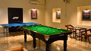 Une salle de billard équipée de plusieurs tables de billard, de chaises et d’une table de jeu de pool.