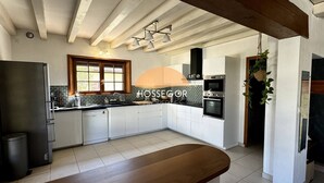 A modern kitchen with white cabinets, a built-in oven, and a large window. - Villa Bonamour - Capbreton - Pool - Port - Beach (Capbreton)