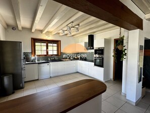Eine moderne Küche mit weißen Schränken, einem eingebauten Backofen und einem großen Fenster.
