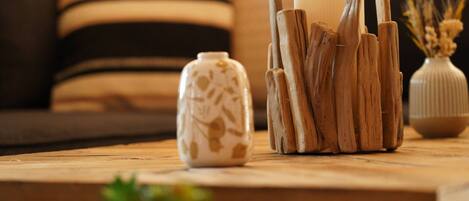 A wooden table with a vase, a candle holder, and a small plant.