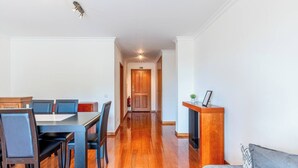 Ein Hotelzimmer mit Essbereich, einem Holzbüro und einem Flur, der zu einer Tür führt.