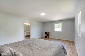 A bedroom with a bed, a walk-in closet, a window, and a small cabinet. - NEW Ranch Home By Duke Hospital & UNC Hospitals (Durham)