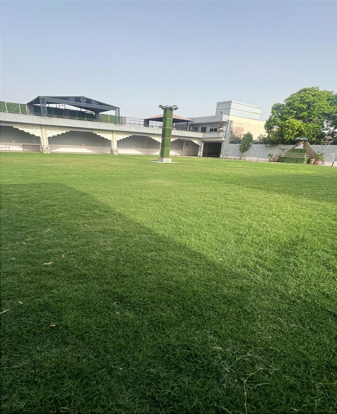 Un patio cubierto de césped con un edificio moderno al fondo.