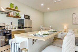 A modern kitchen with a dining area, a refrigerator, microwave, and a stove. - Patio & Grill! Modern Studio Near Sofi Stadium (Los Angeles)