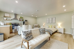 A modern bedroom with a bed, bedside tables, and a nightstand. - Patio & Grill! Modern Studio Near Sofi Stadium (Los Angeles)