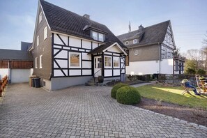 A traditional half-timbered house with a paved driveway and a small lawn. - Apartment 'Huckelberg' with Wi-Fi (Schmallenberg)