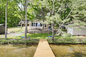 A wooden dock leading to a house surrounded by trees and a small stream. - Boat, Fish, Relax! Crescent Lake Retreat w/ Dock (Rhinelander)