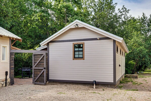 A small, single-story building with a sloped roof, a window, and a door.