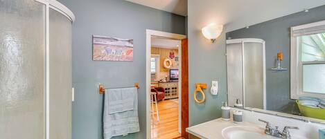 A bathroom with a white sink, a mirror, and a towel rack.