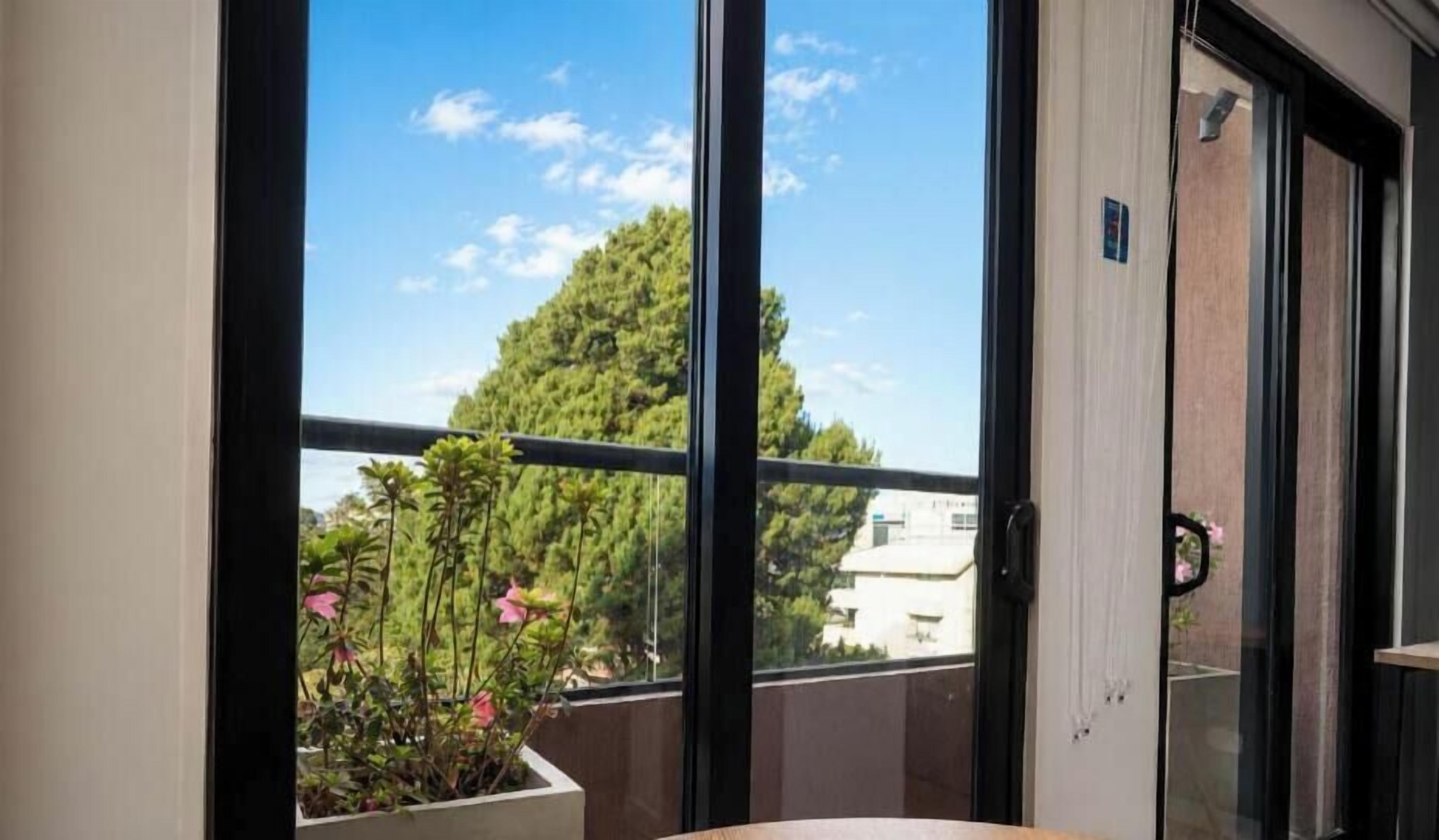 A balcony with a view of a tree and a building.