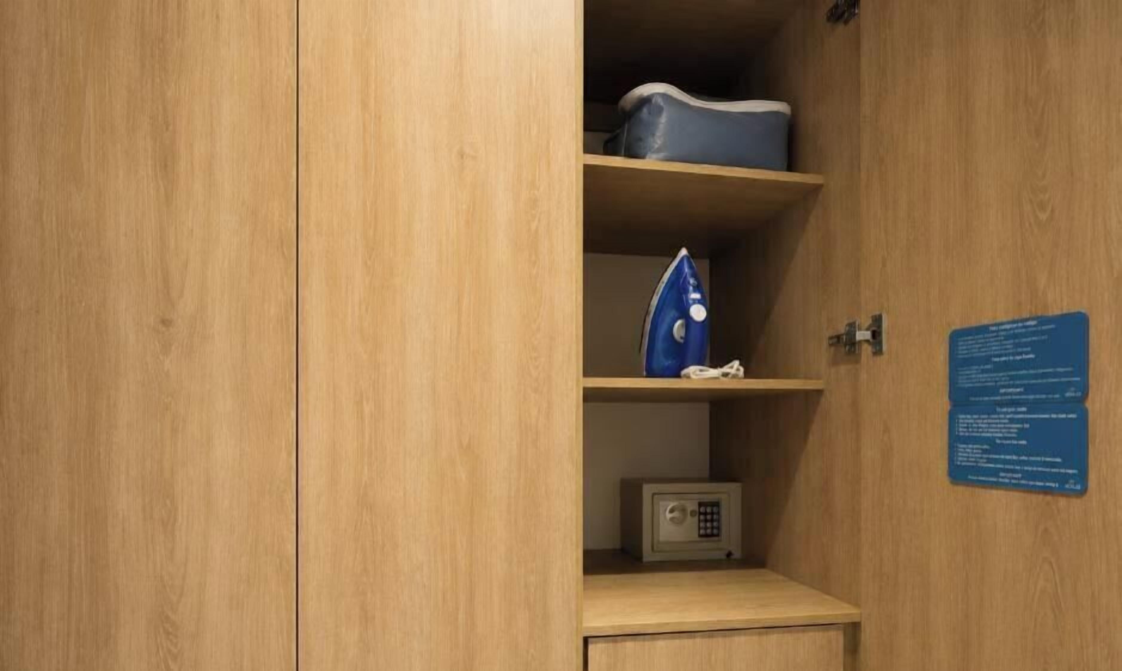 Un mueble de madera con un letrero azul, una bolsa azul y una caja de seguridad pequeña.