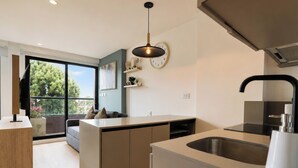 Una cocina moderna con isla integrada, un ventanal grande y un comedor con sofá.