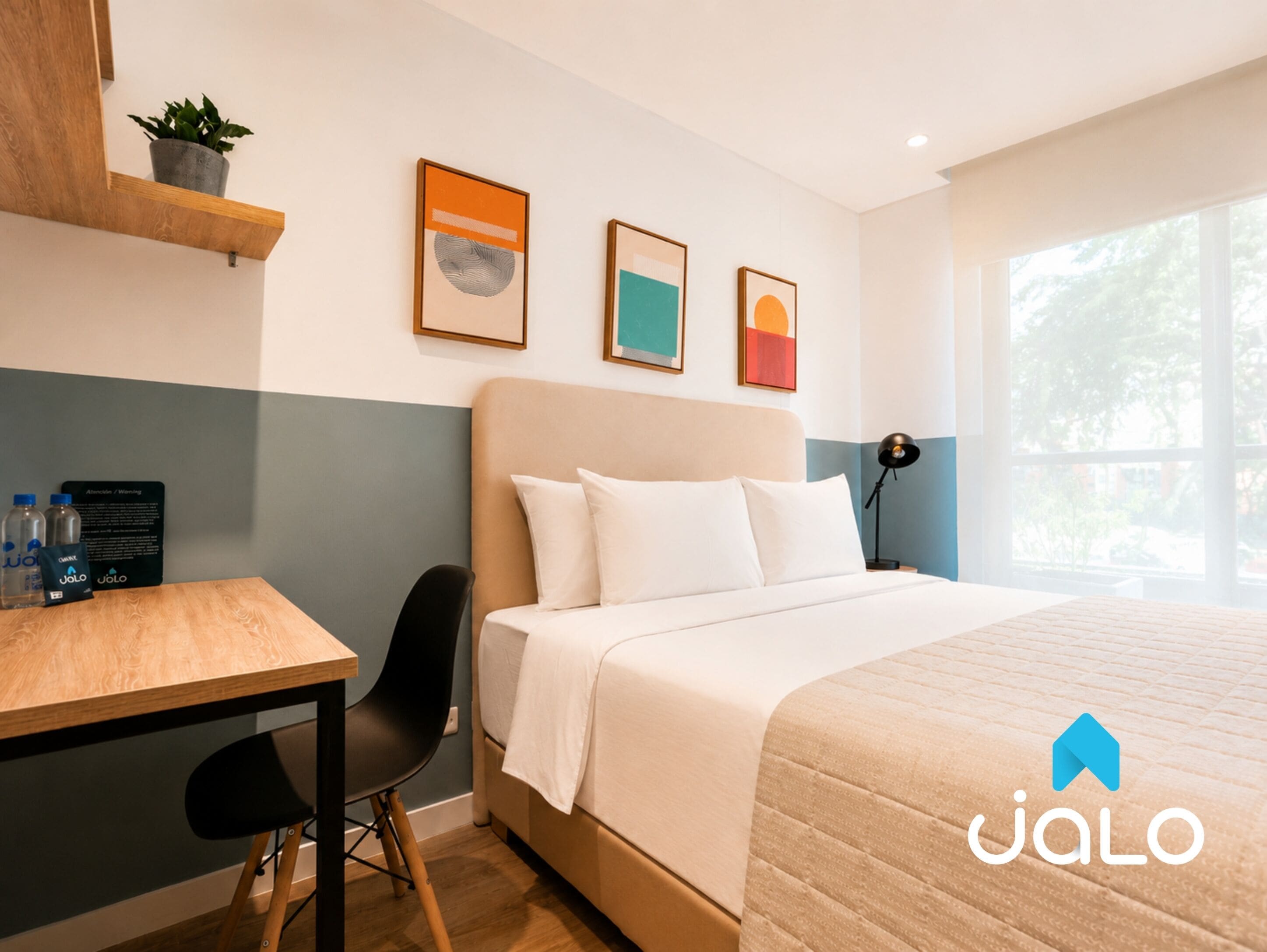 A hotel room with a bed, desk, chair, and a window.