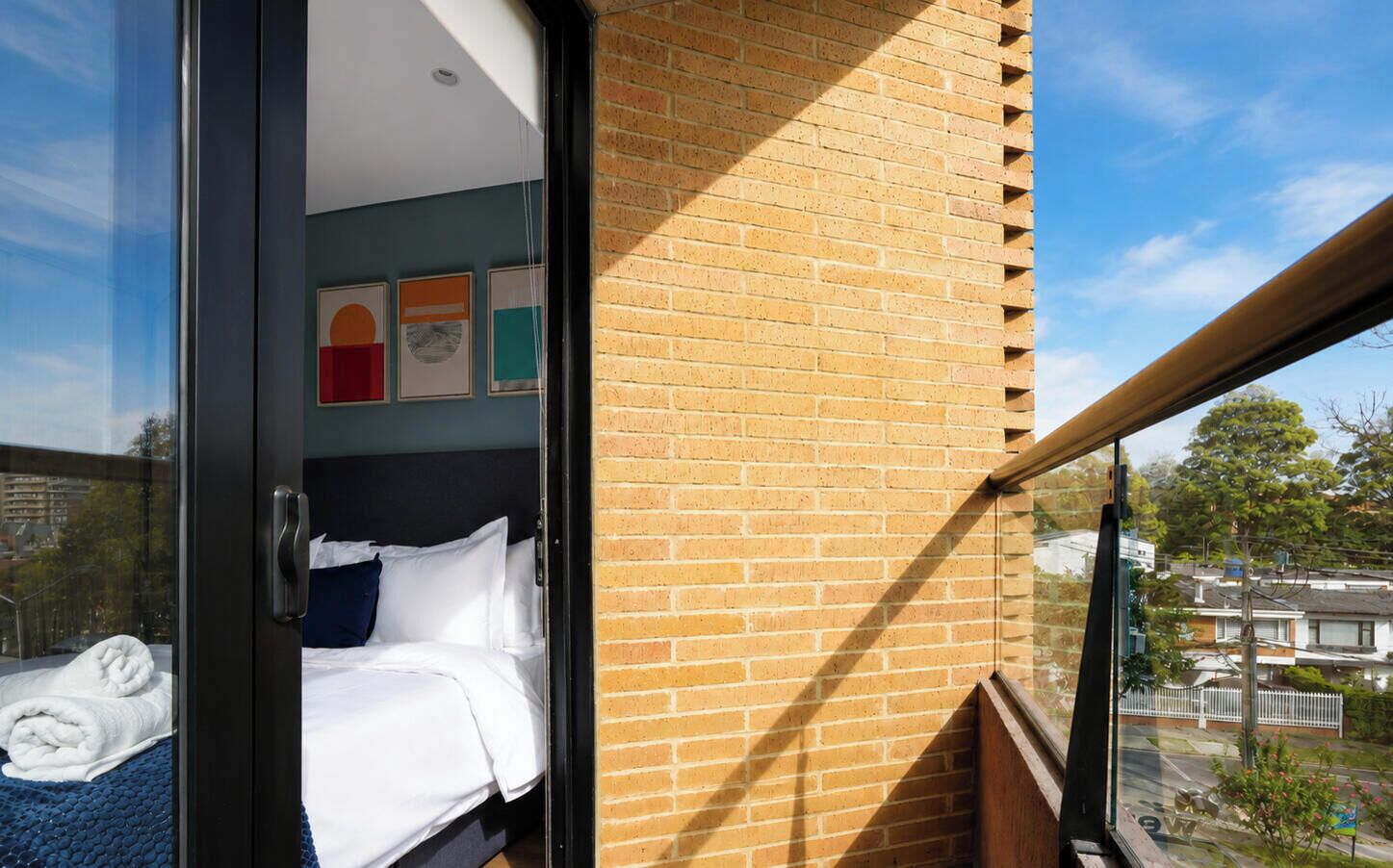 A hotel room with a bed, a window, and a view of the outside.