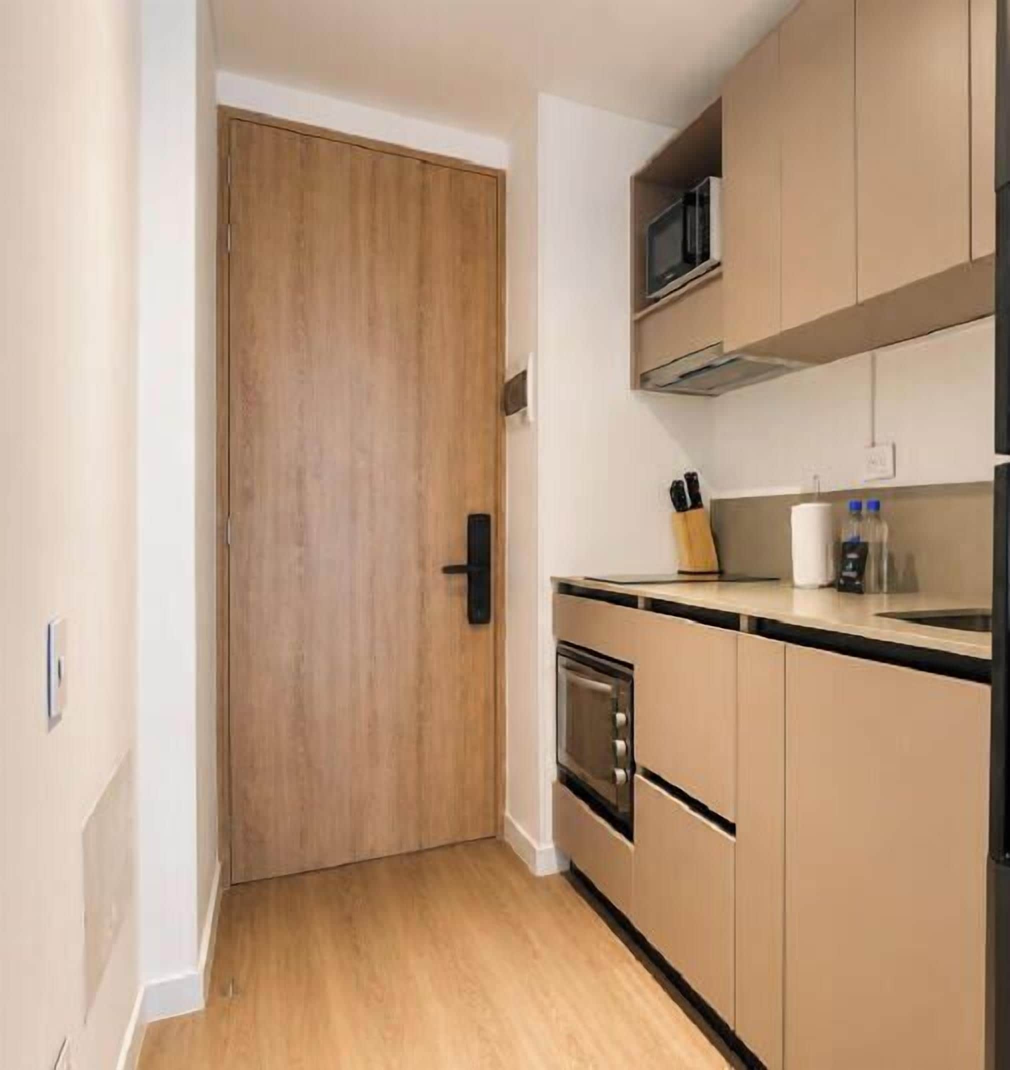 A kitchen with wooden cabinets, a microwave, and a stove.