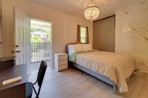 Ein Schlafzimmer mit Bett, Nachttisch, Stuhl und einer Deckenleuchte.