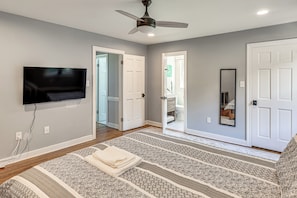 A bedroom with a bed, a ceiling fan, a TV mounted on the wall, and a door leading to another room. - 3 Mi to Dtwn: Spacious Warsaw Retreat w/ Huge Yard (Warsaw)