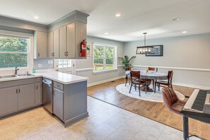 A kitchen with grey cabinets, a dishwasher, and a dining area with a piano. - 3 Mi to Dtwn: Spacious Warsaw Retreat w/ Huge Yard (Warsaw)