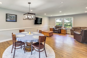 A dining area with a round table, chairs, and a chandelier. There is a flat-screen TV mounted on the wall. - 3 Mi to Dtwn: Spacious Warsaw Retreat w/ Huge Yard (Warsaw)