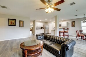 A spacious living area with a leather sofa, a glass coffee table, and a ceiling fan. - Near The Woodlands! Group Retreat w/ Yard & Patio (Spring)