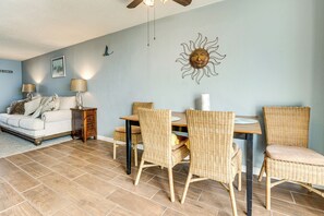 Ein Essbereich mit Korbstühlen, einem Holztisch und einem Deckenventilator.