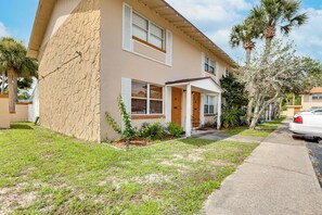 A two-story house with a stone facade, a front porch, and a car parked on the street. - Centrally Located! Brand New South Daytona Retreat (Daytona Beach)