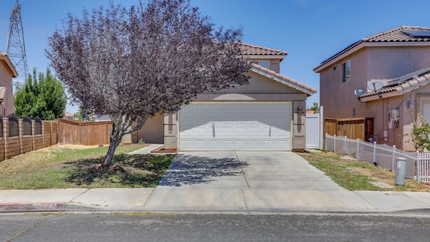 A residential street with houses, a tree, and a clear sky. - Convenient High Desert Stay Near Route 66 (Victorville)