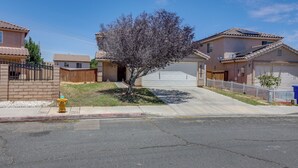 A residential street with houses, a tree, a fire hydrant, and a garage. - Convenient High Desert Stay Near Route 66 (Victorville)