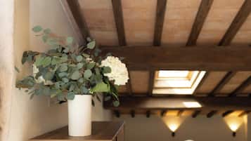 Un mueble de madera con un jarrón de flores, un sofá y un tragaluz en una habitación con techo inclinado.